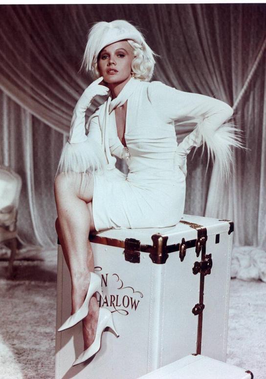 Jean Harlow showing her box while wearing furry white gloves.